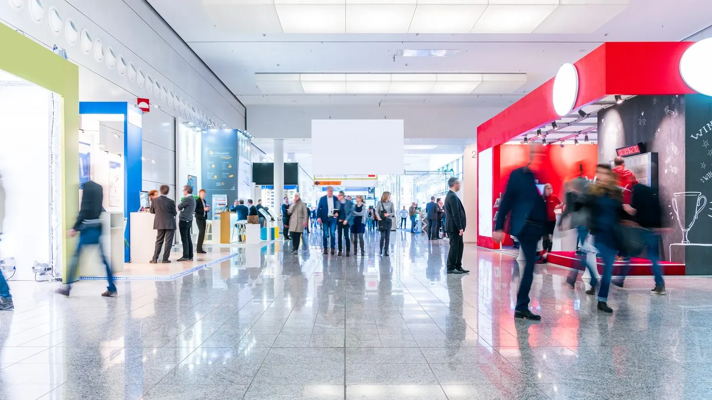 Visitors walking through a bright indoor concourse.