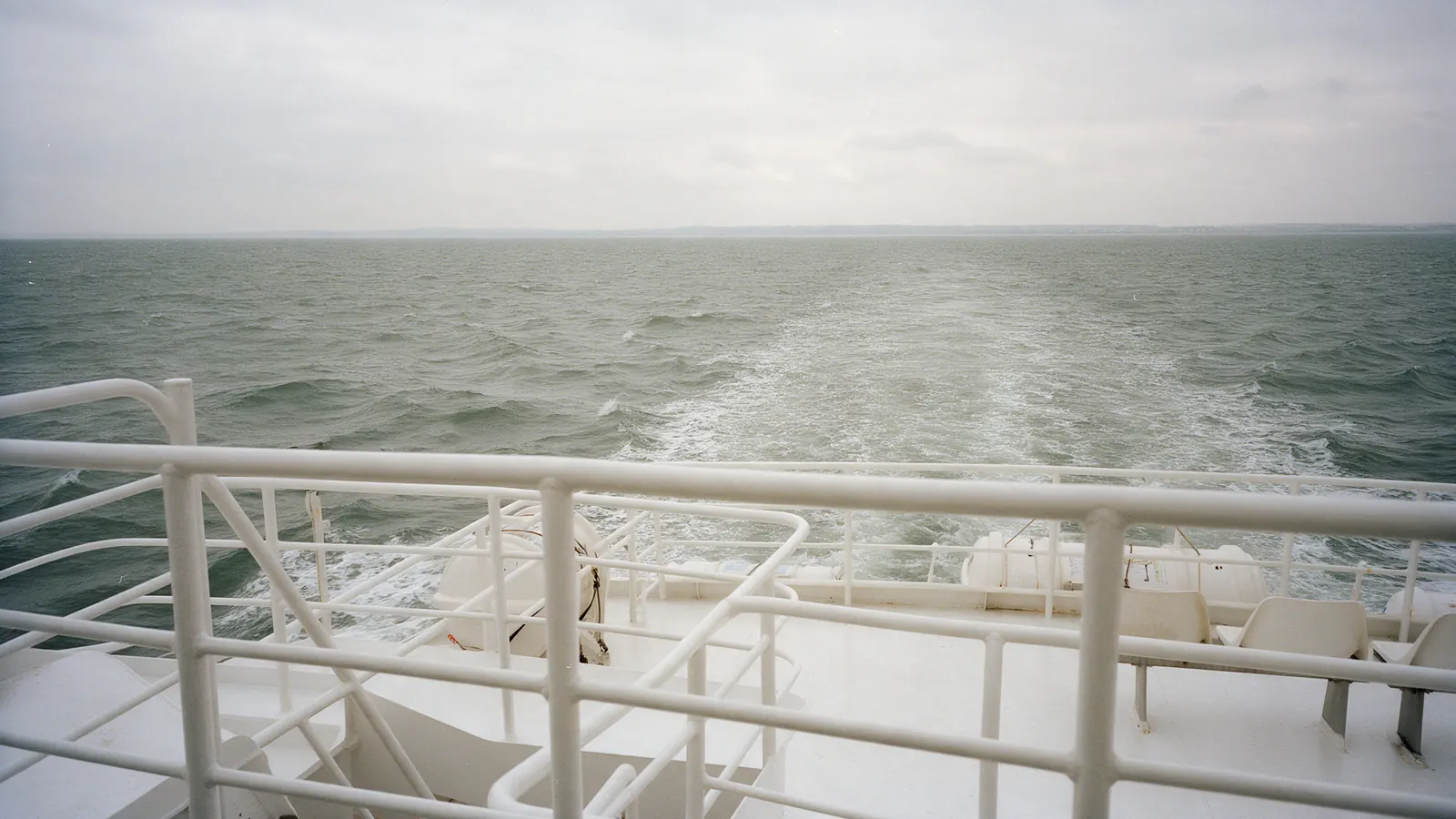 A passenger ferry deck on a grey day at sea: island crossings from Tokyo are short, but they run only when the weather allows.