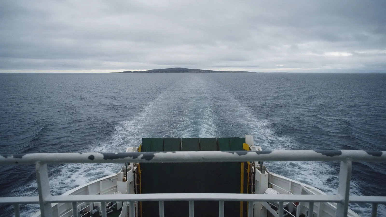 Looking back from the deck of a car ferry across a grey northern sea.