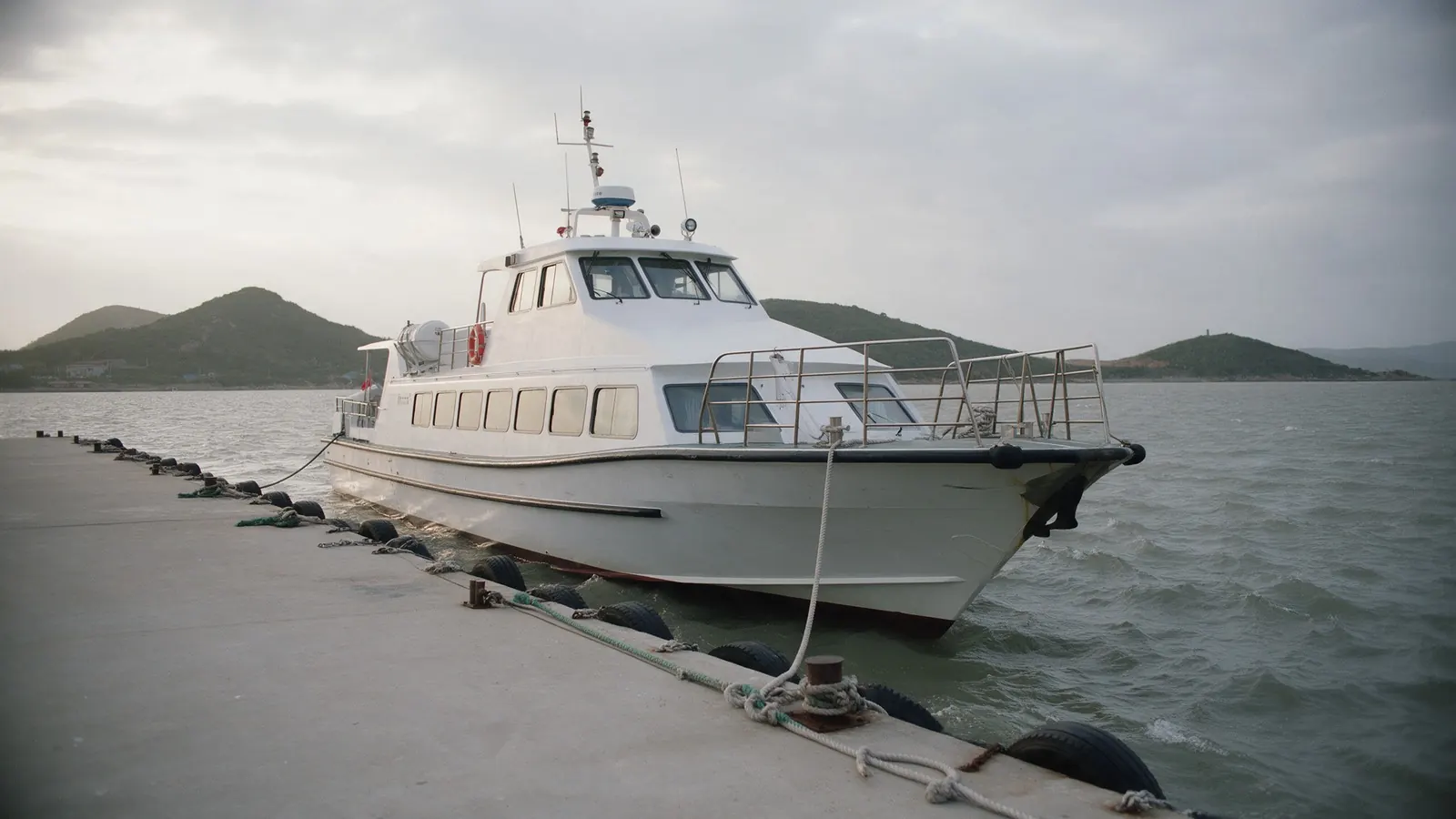 A small passenger ferry moored at a quiet harbour quay.