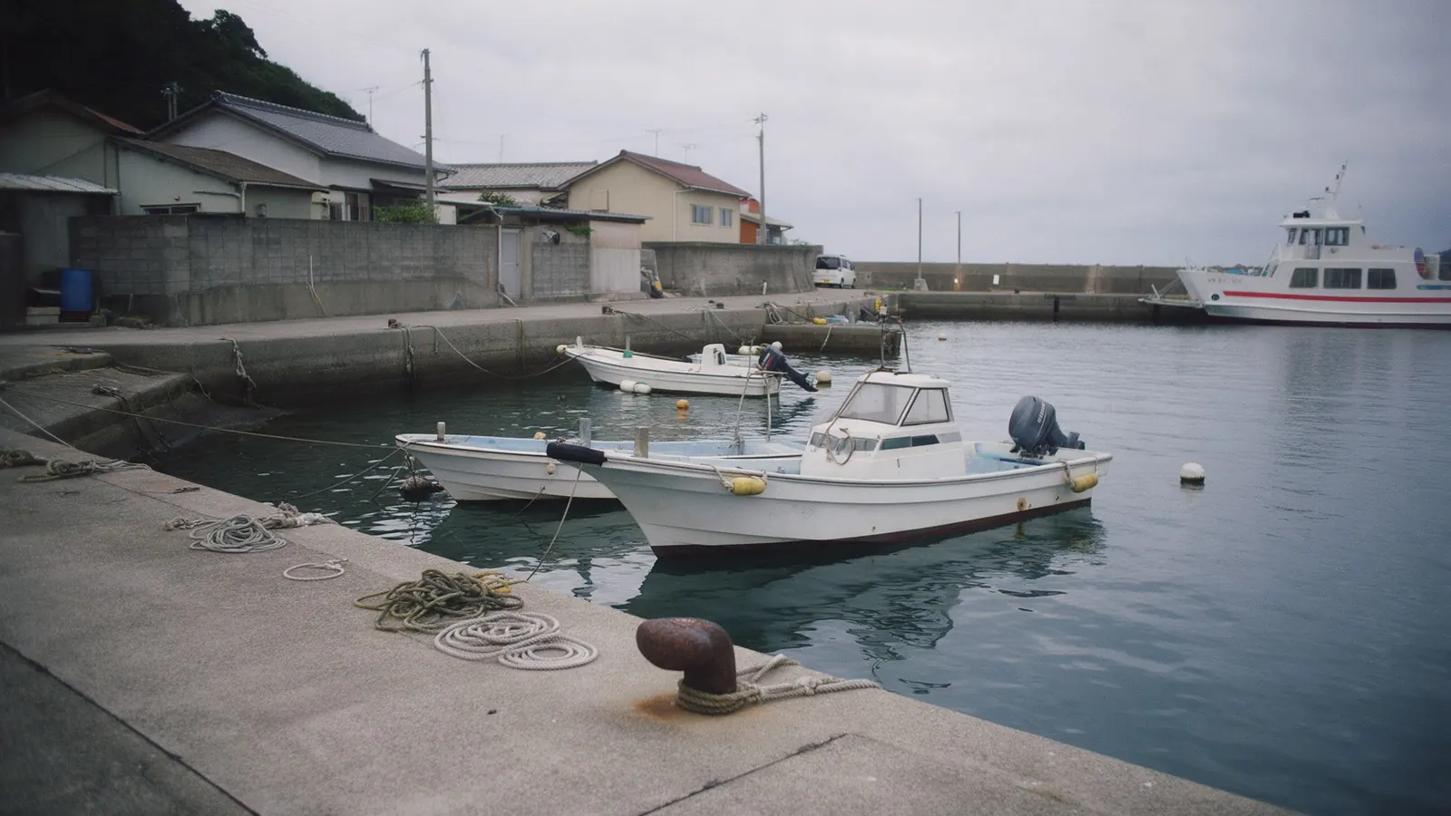 A small island harbour with fishing boats and a ferry at the quay: facilities on the islands are limited.