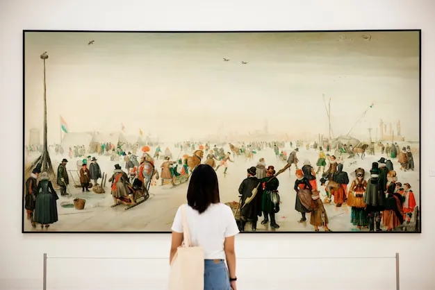 A visitor looks at a large painting of a winter scene on a white wall.