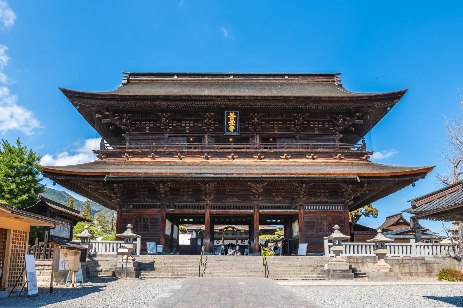 Zenko-ji's Sanmon gate under a clear sky.